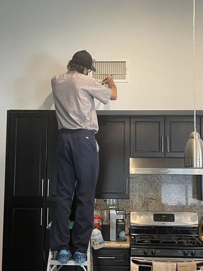Technician inspecting an air vent during HVAC service in Lakeland Highlands